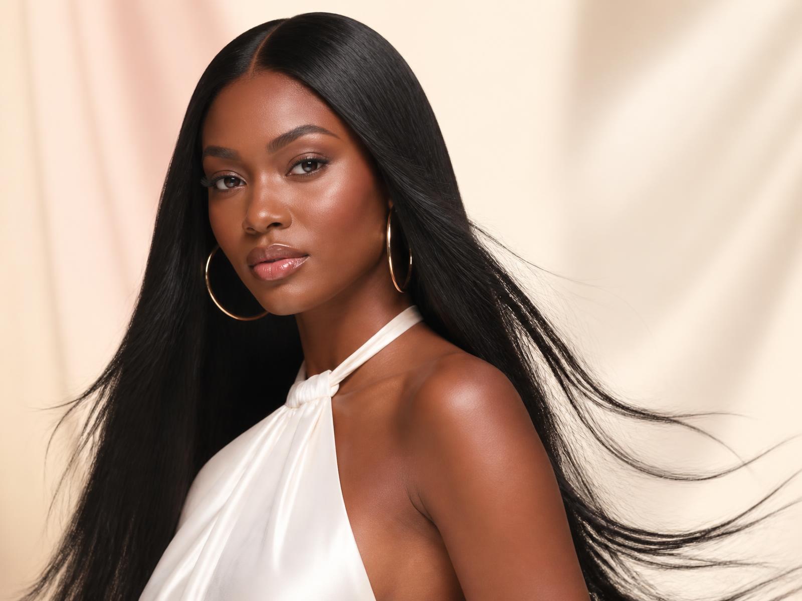 Professionally styled long straight hair in a cream and blush beauty campaign setting